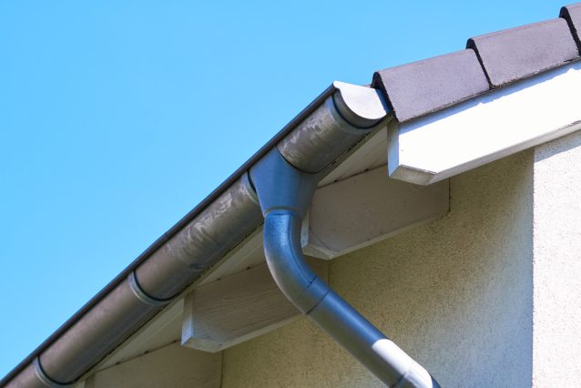 Gutter with downpipe on the roof of a house — URB’n Roofing | Brisbane